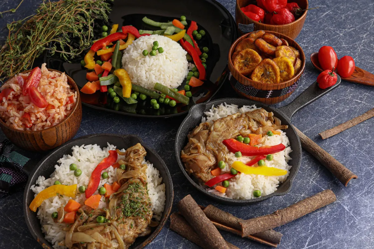 Plate of traditional Antiguan food including jerk chicken, rice and peas, and fried plantains