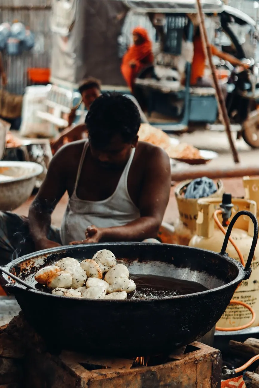 Street food vendor preparing spicy skewers