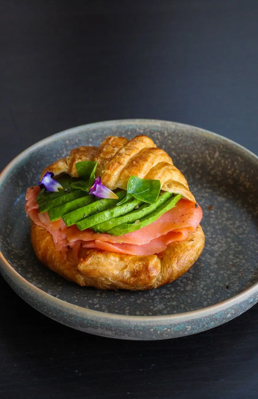 A chef skillfully assembling a pintxo with smoked salmon and cream cheese