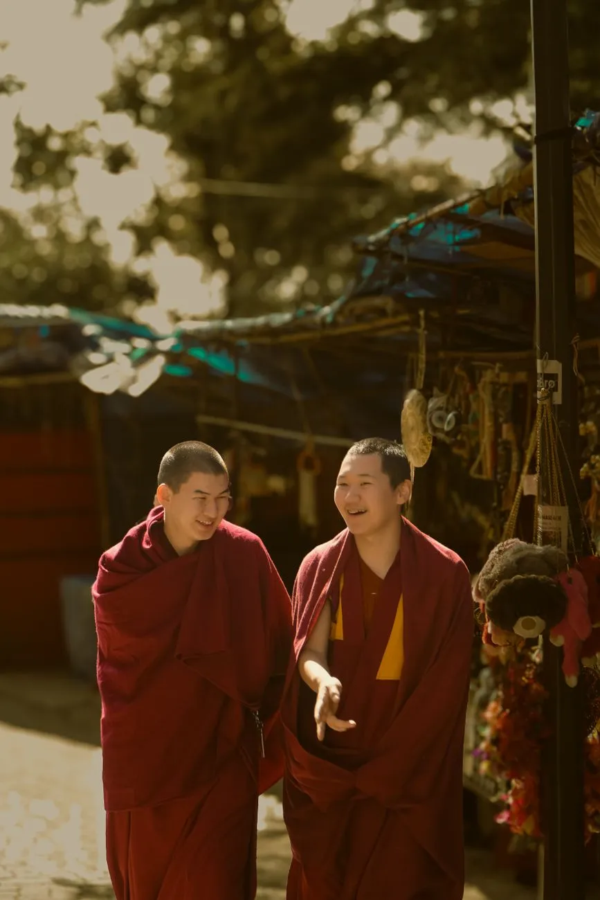 Monks in maroon robes walking through the courtyard of Paro Taktsang Monastery, Bhutan