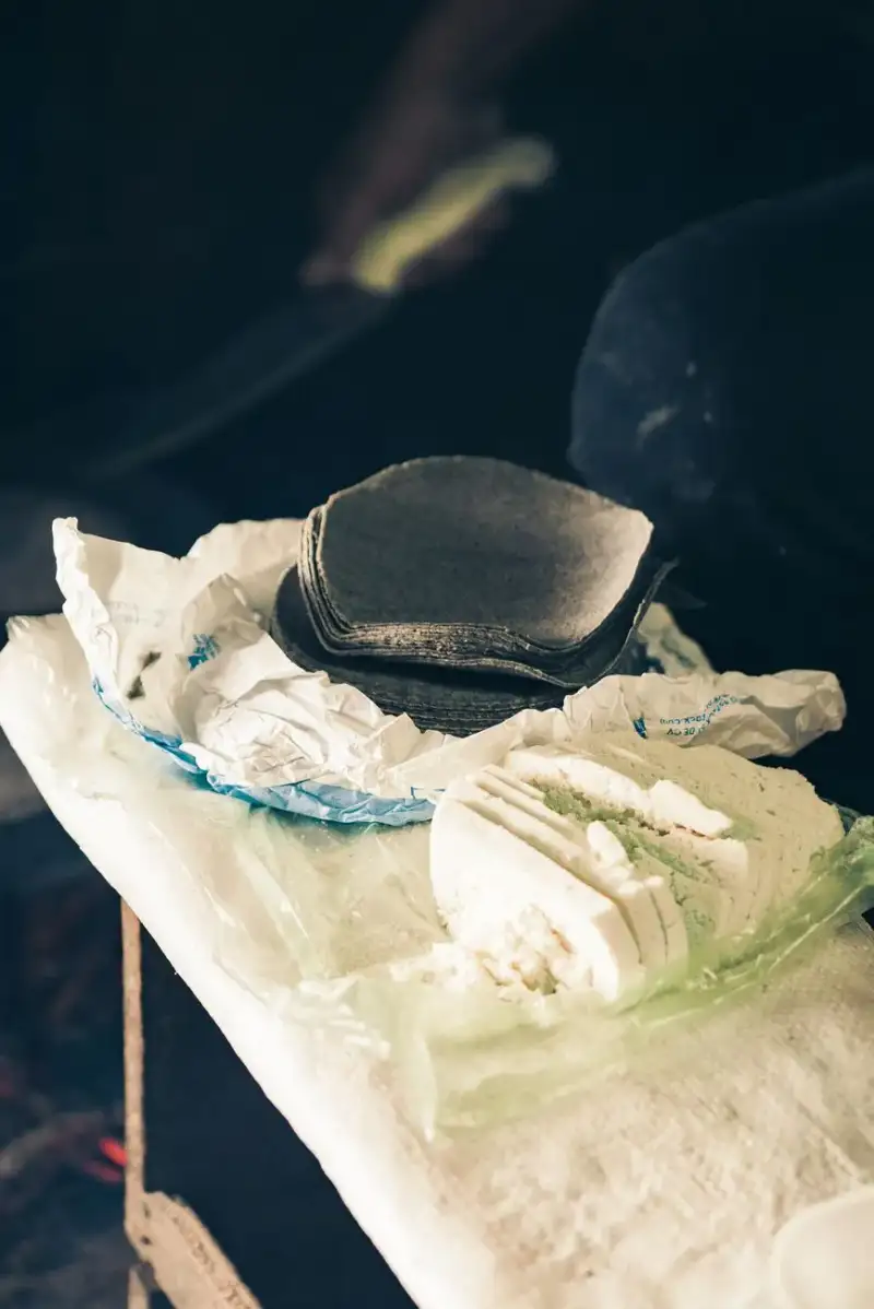 Historische Darstellung des mexikanischen Landlebens mit Menschen, die traditionelle Maistortillas zubereiten, in warmen Sepia-Tönen, authentisch und rustikal