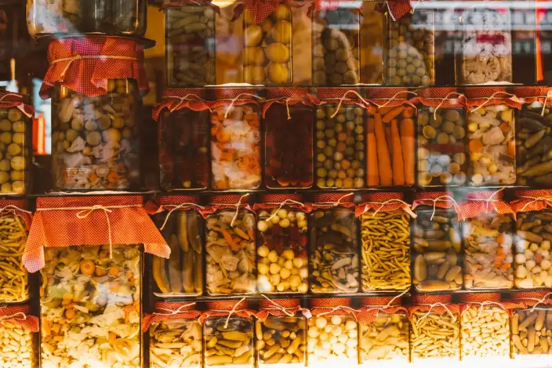 Eine bunte Auswahl an fermentiertem Gemüse, Milchprodukten und Getränken, appetitlich auf einer modernen Kücheninsel präsentiert