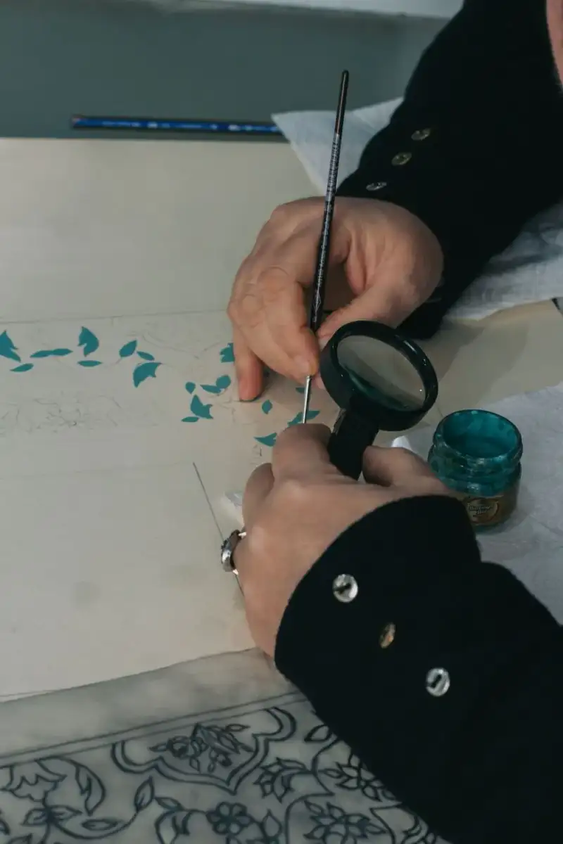 A skilled artisan's hands meticulously restoring an old, faded manuscript page with a fine brush and ink, surrounded by antique writing tools and soft, focused light, illustrating detailed and careful work