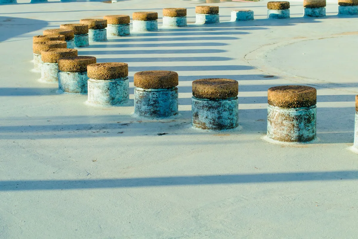 Futuristic IoT sensor node embedded in a concrete wall, harvesting ambient RF energy from nearby transmitters