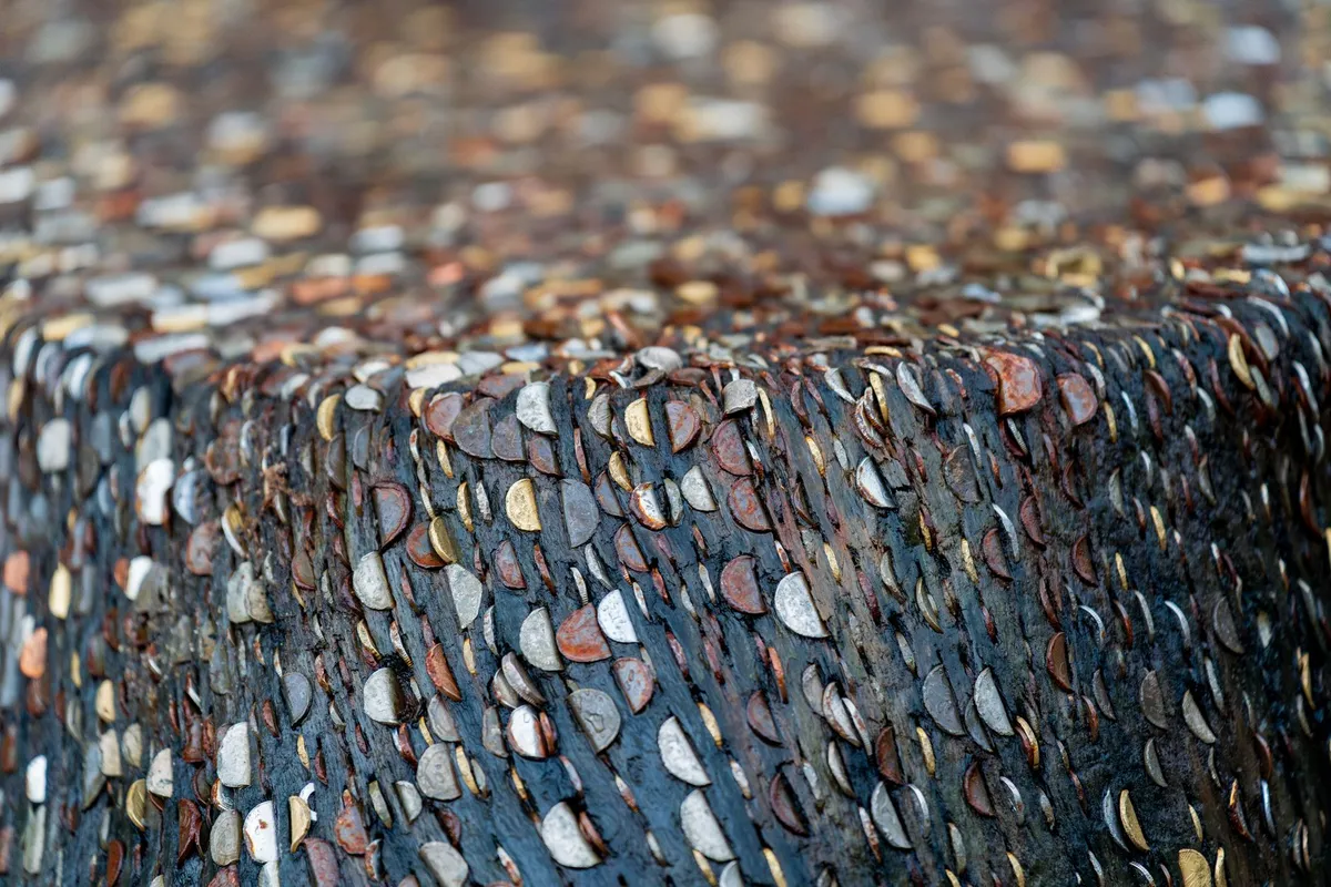 Close-up of a piezoelectric energy harvester embedded in a concrete surface, with visible micro-cracks and energy-harvesting circuitry