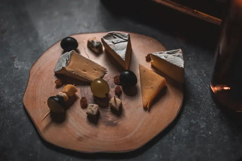 A beautifully arranged cheese board with wine and fruit