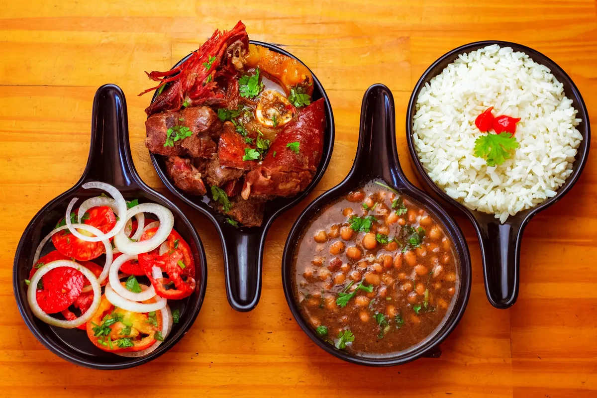 A steaming pot of feijoada simmering on a rustic stove