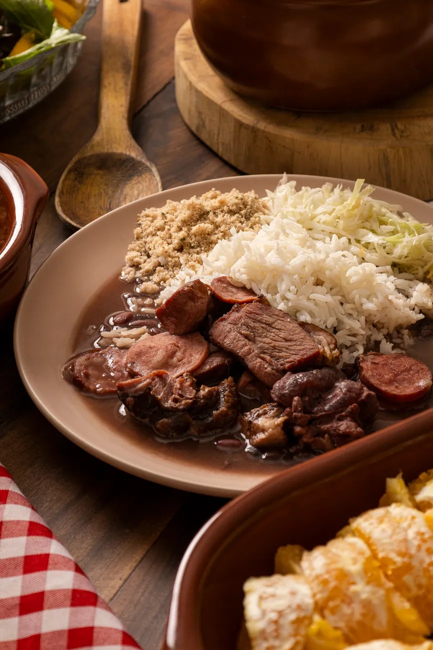 A close-up of a spoonful of feijoada, revealing tender pork and black beans