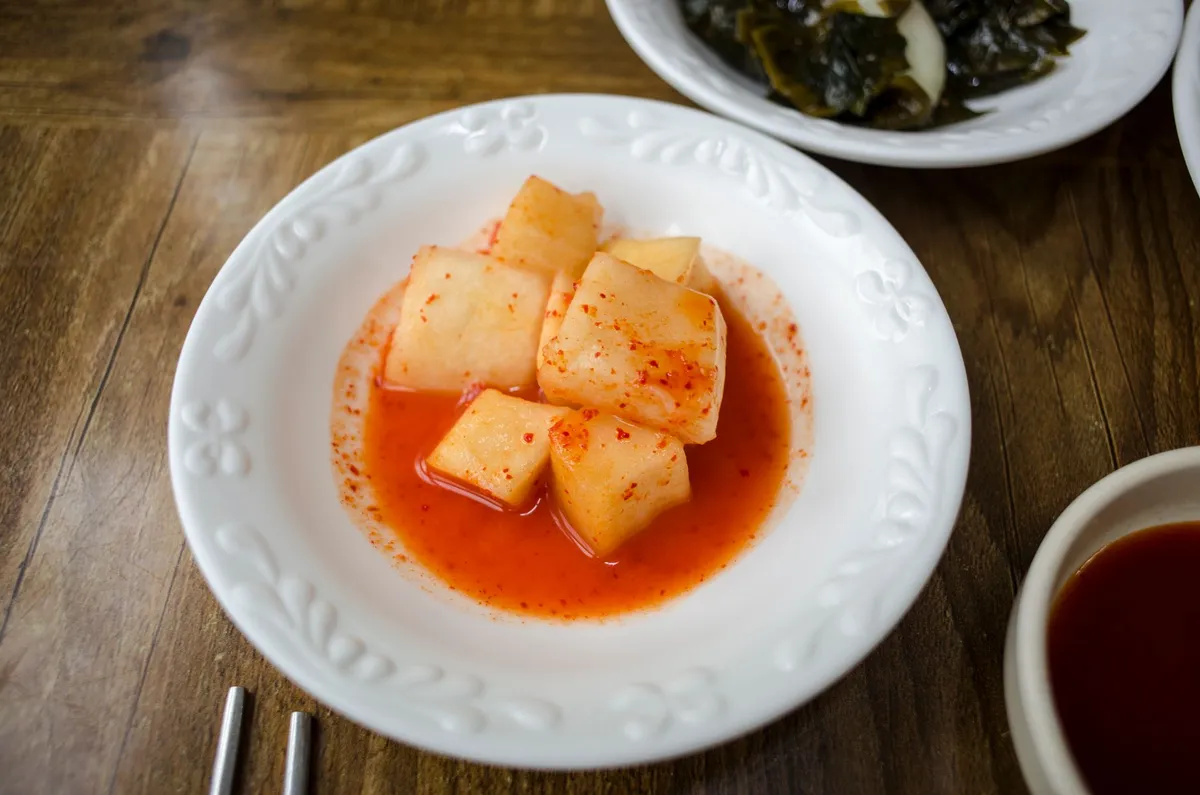 A close-up of a jar of kimchi with visible bubbles indicating active fermentation