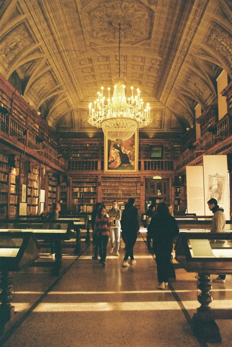 Monaci medievali osservano un falò di libri proibiti in una piazza cittadina.