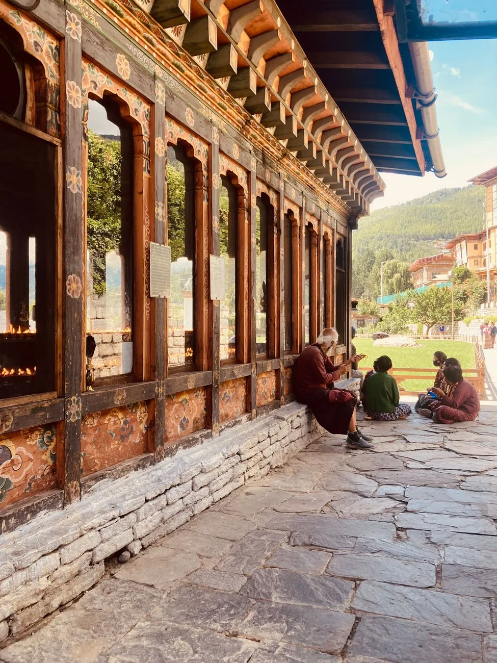 Monks walking near the cliffside entrance of the temple