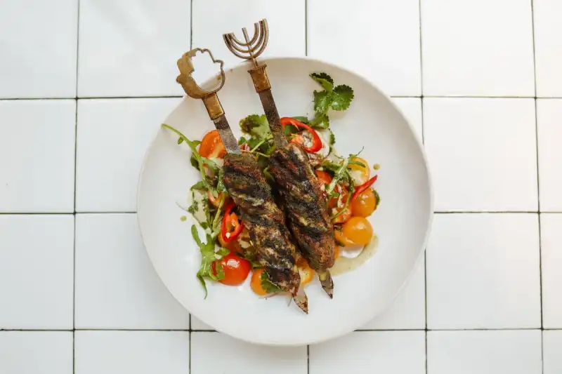 Plated chicken shish kebab with sumac salad and rice