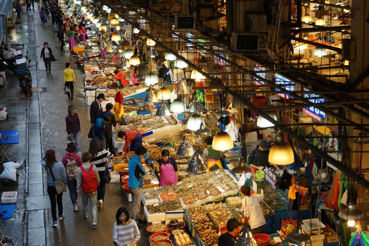 Image of a bustling street food market with vendors and customers