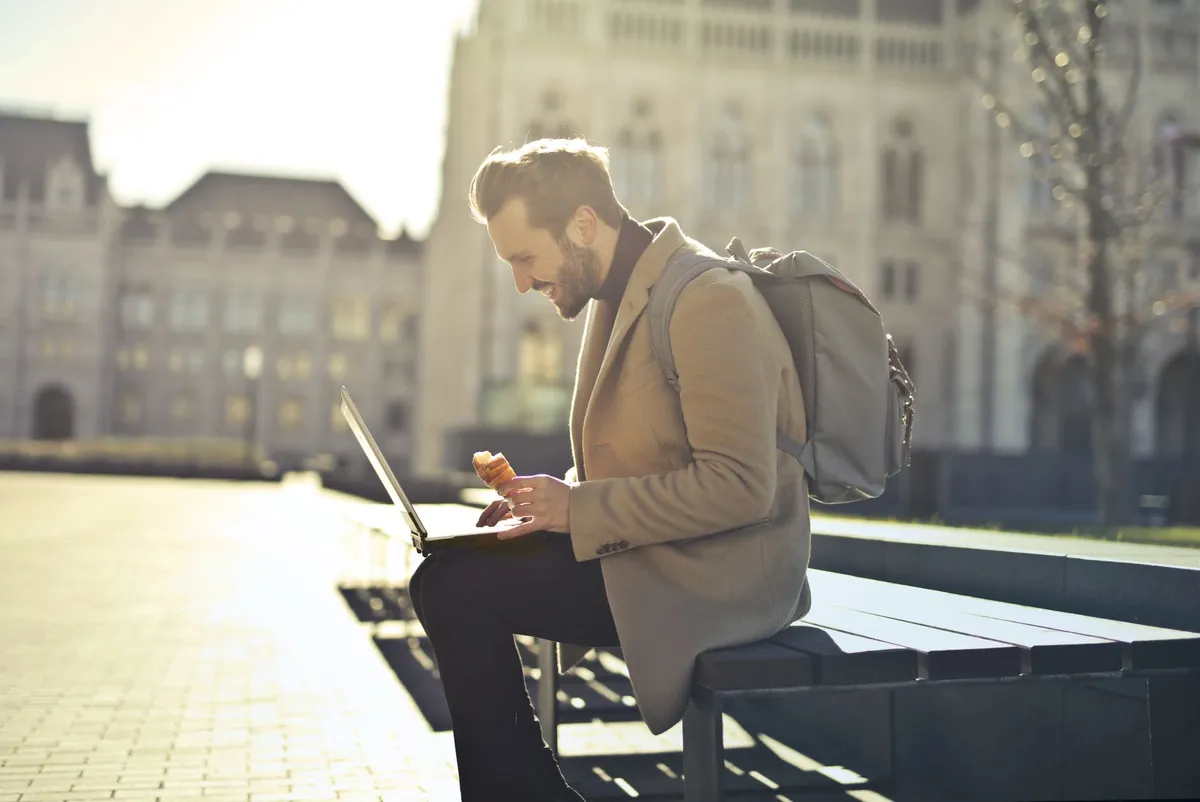 A digital nomad working from a café in a historic European square