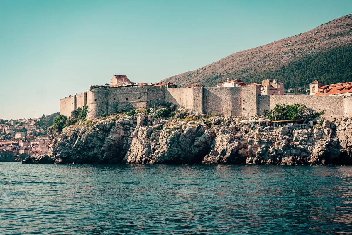 Dalmatian Coast road with historic walled city and turquoise Adriatic Sea