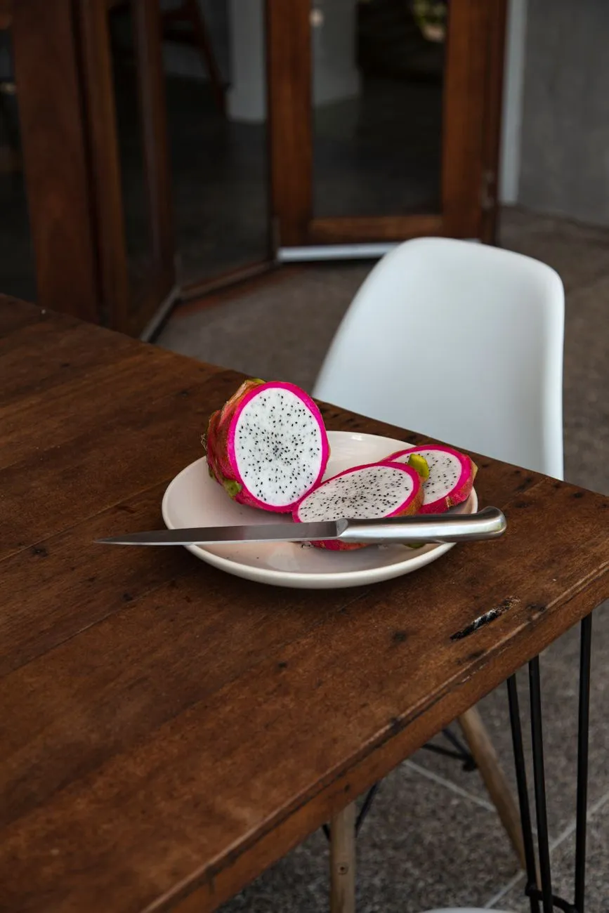 Dragon fruit cut in half showing pink flesh and black seeds