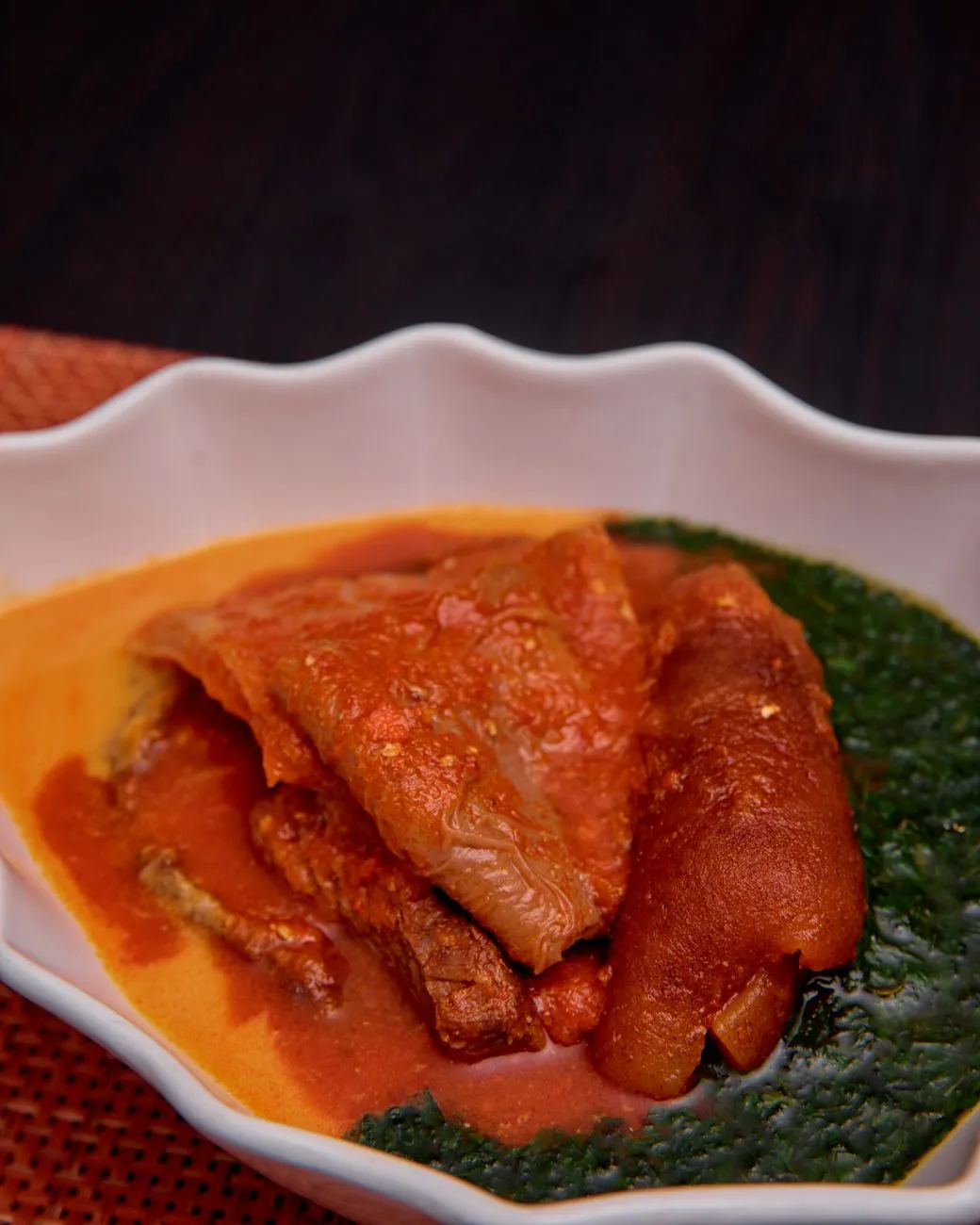 A bowl of Ghanaian fufu with light soup and a side of plantains
