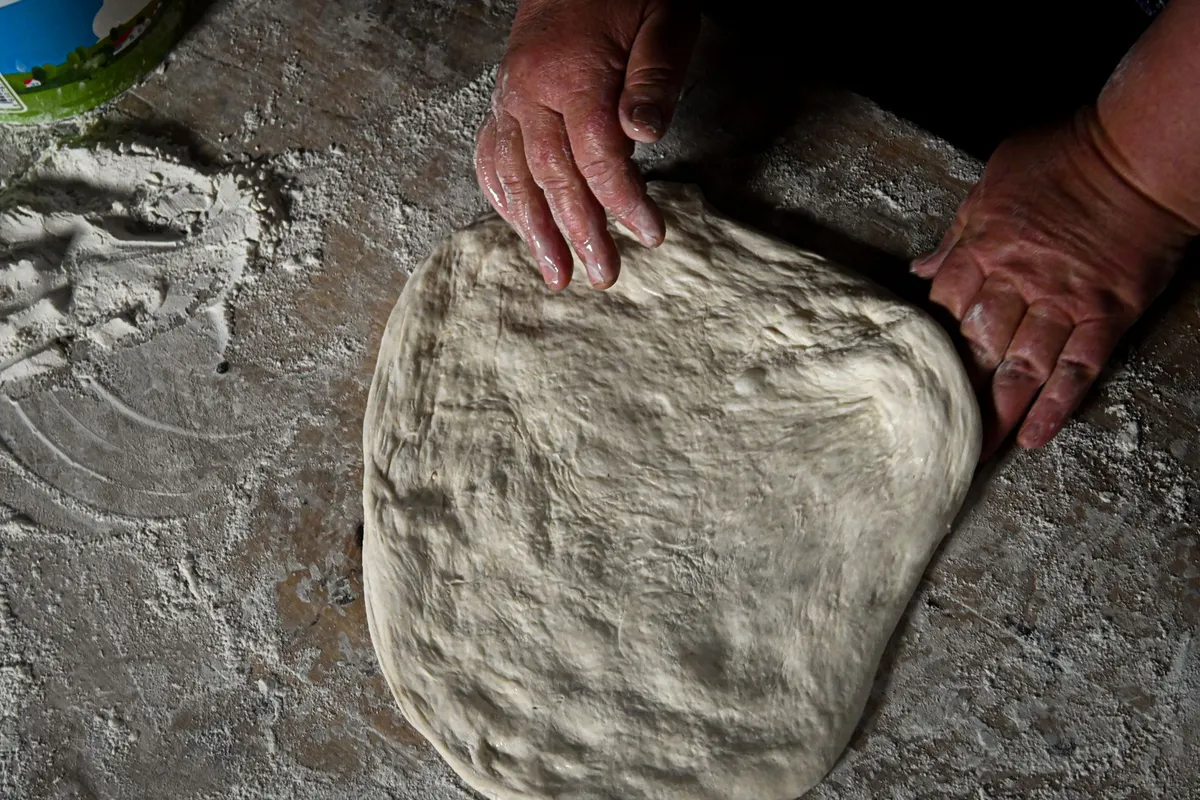 Traditional Neapolitan pizza being stretched by hand