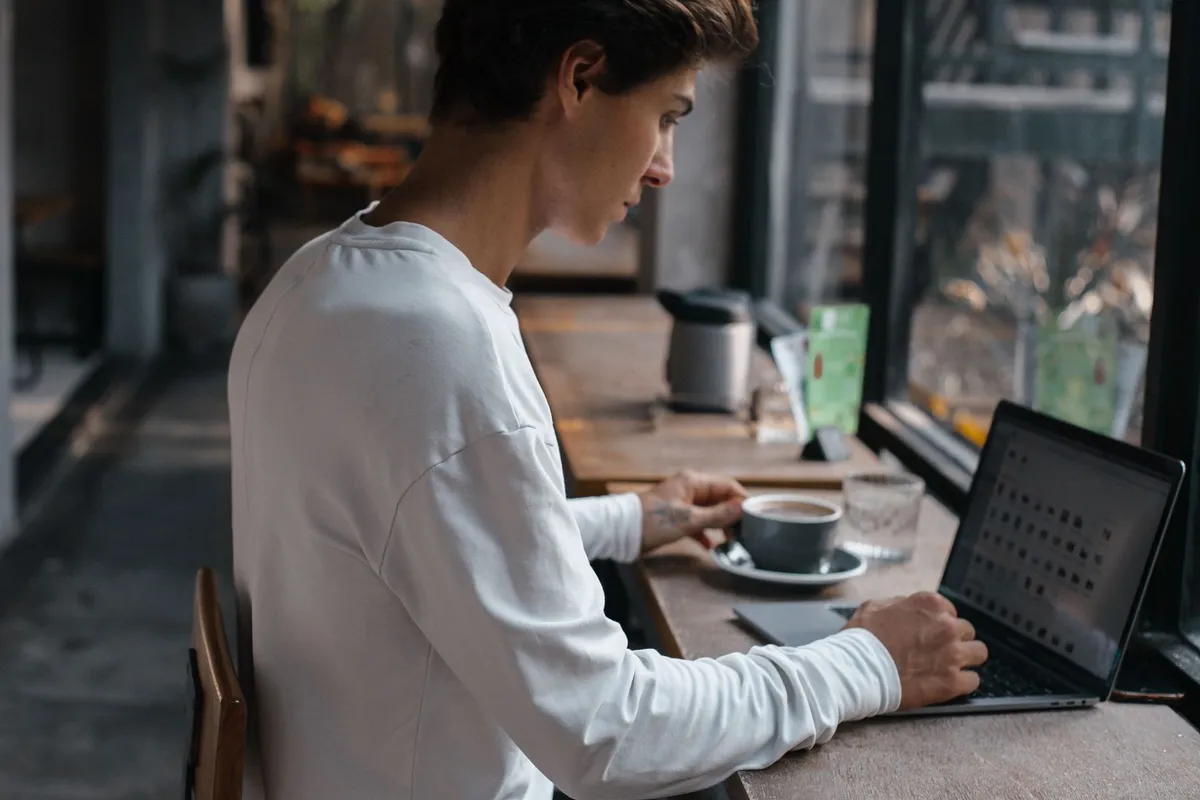 A digital nomad working on a laptop at a café in Lisbon