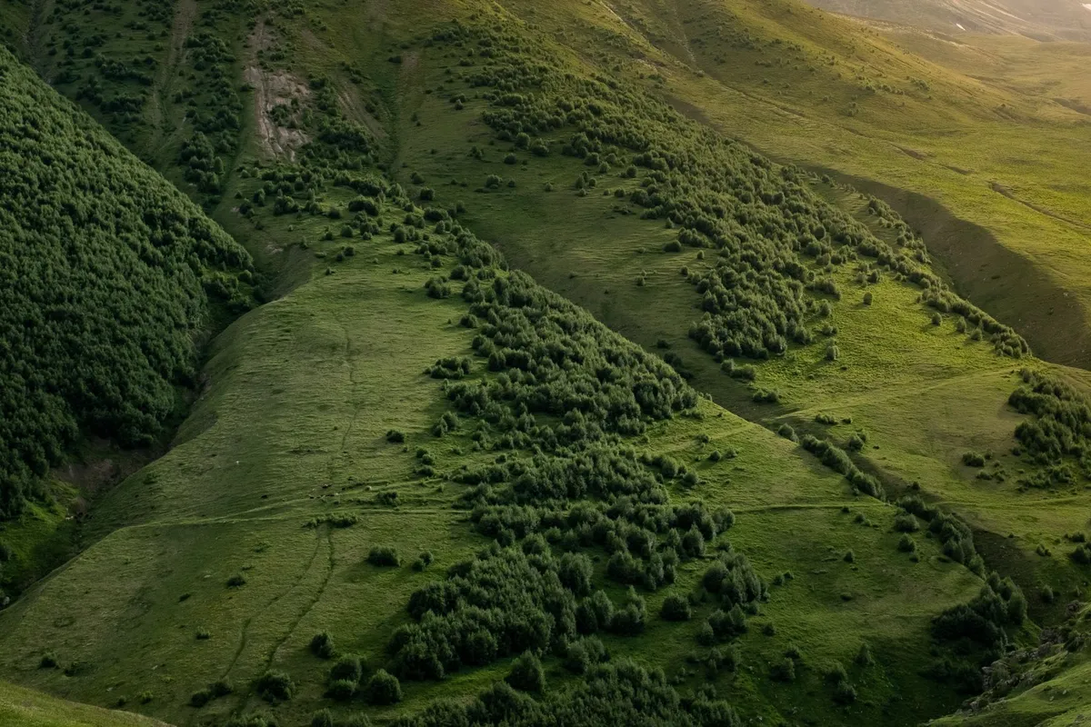 Aerial view of the Caucasus Mountains in Georgia with snow-capped peaks and green valleys