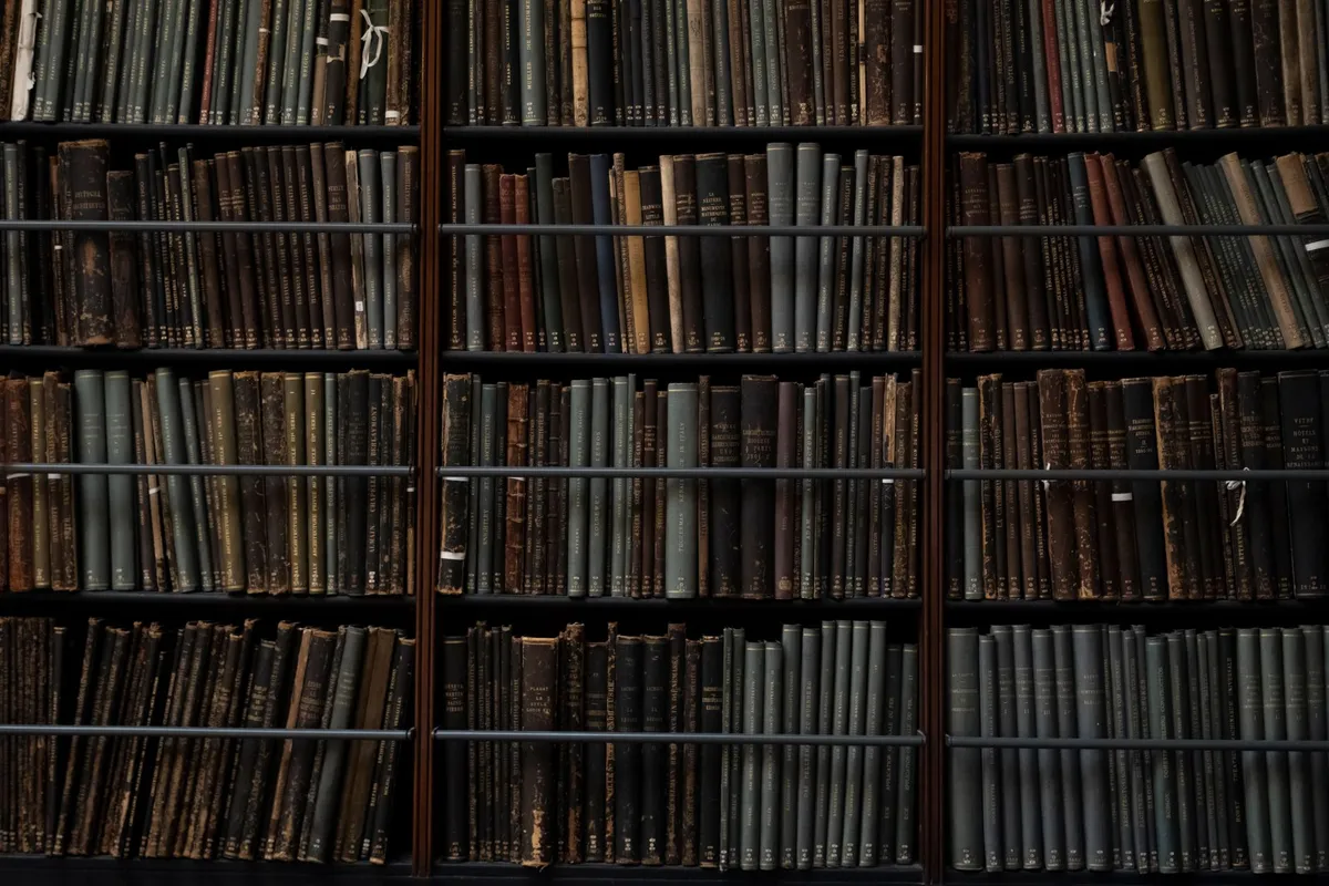 A dark room with stacks of old dusty books