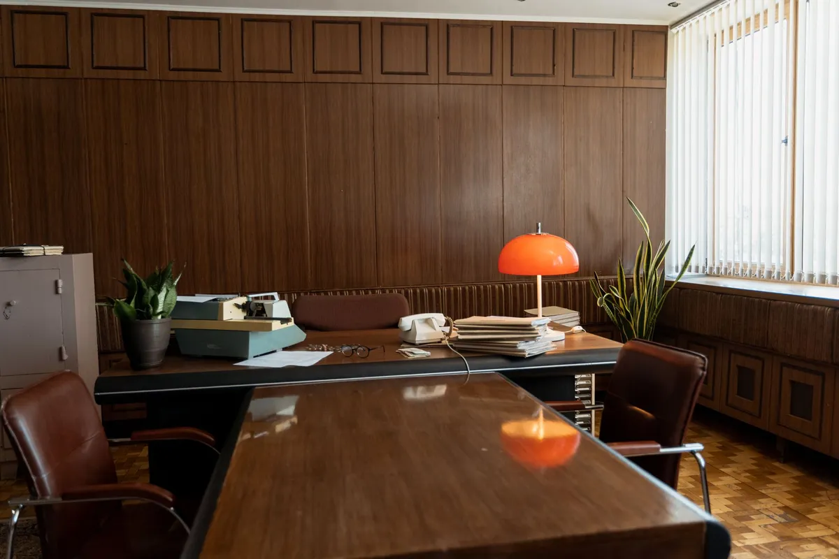 A dark moody room with a single lamp illuminating an open old book