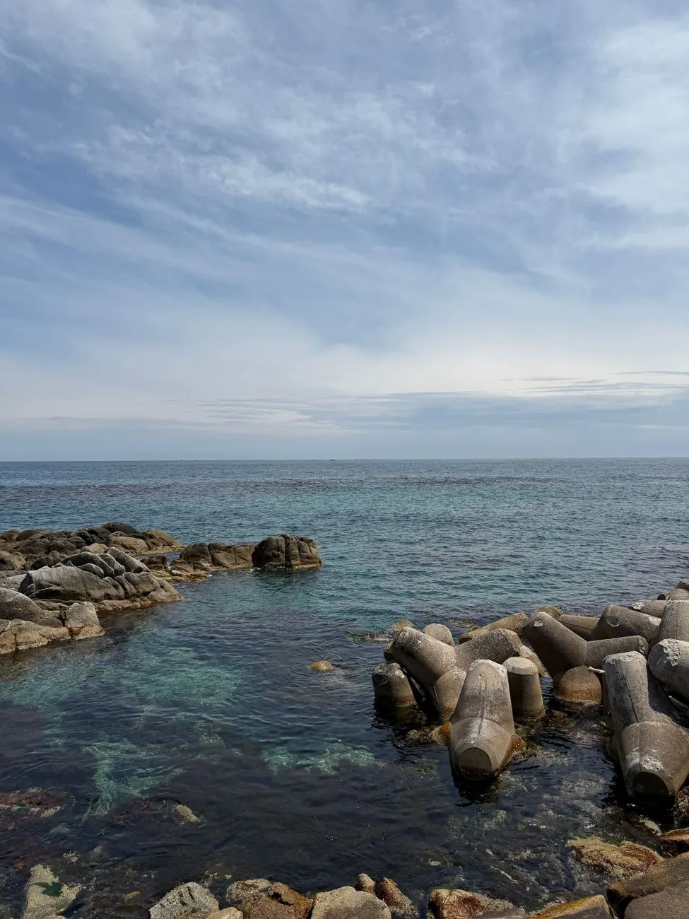 A cliffside onsen bath overlooking the Pacific Ocean, with waves crashing below