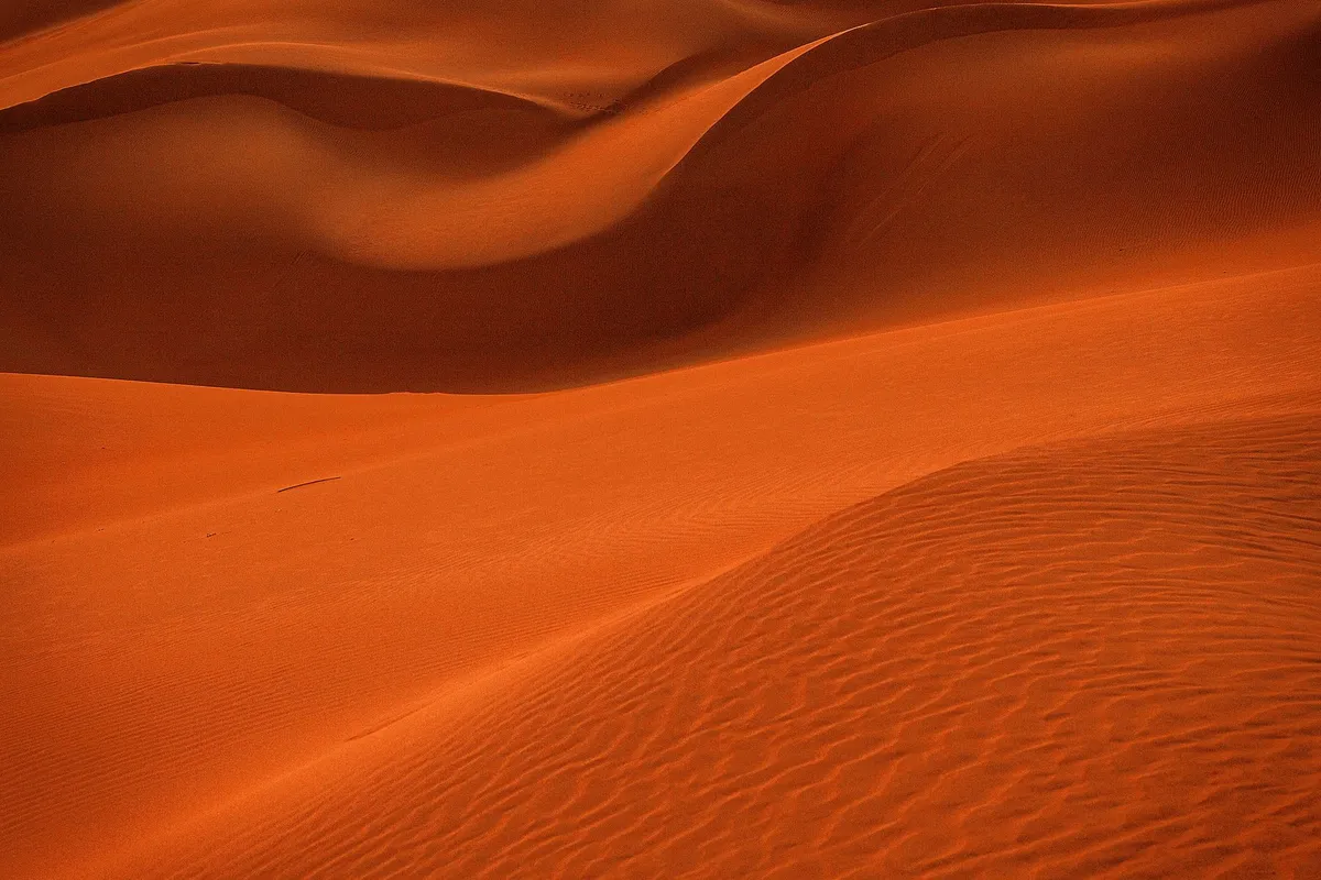 Golden hour in the desert with footprints in sand