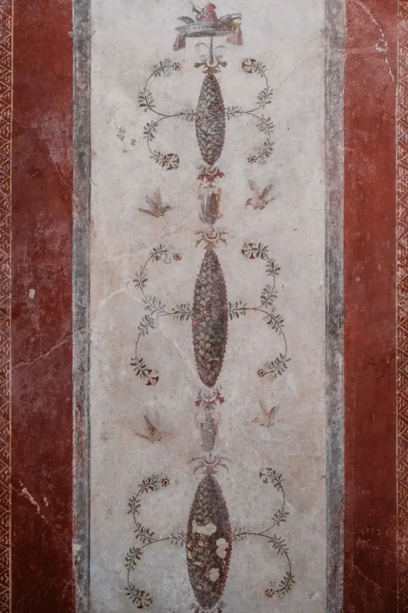 Affresco antico romano con focaccia e frutta su piatto d'argento in una cucina pompeiana, luce naturale, dettagli storici