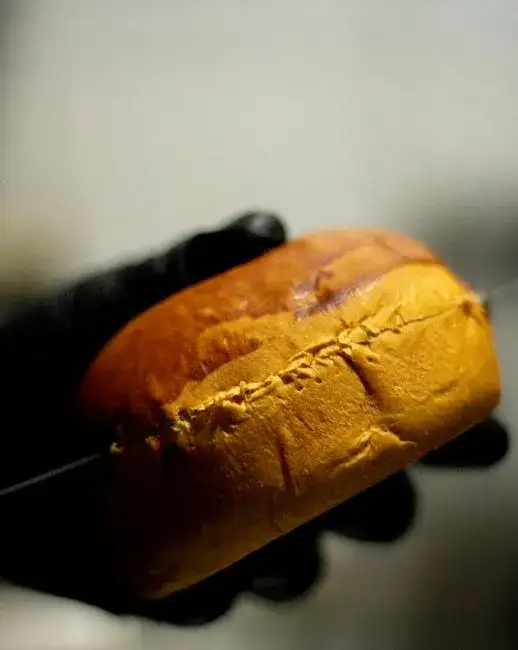 Artisanal bottarga slicing on a wooden board, olive oil drizzle, lemon wedges, close-up, rustic kitchen