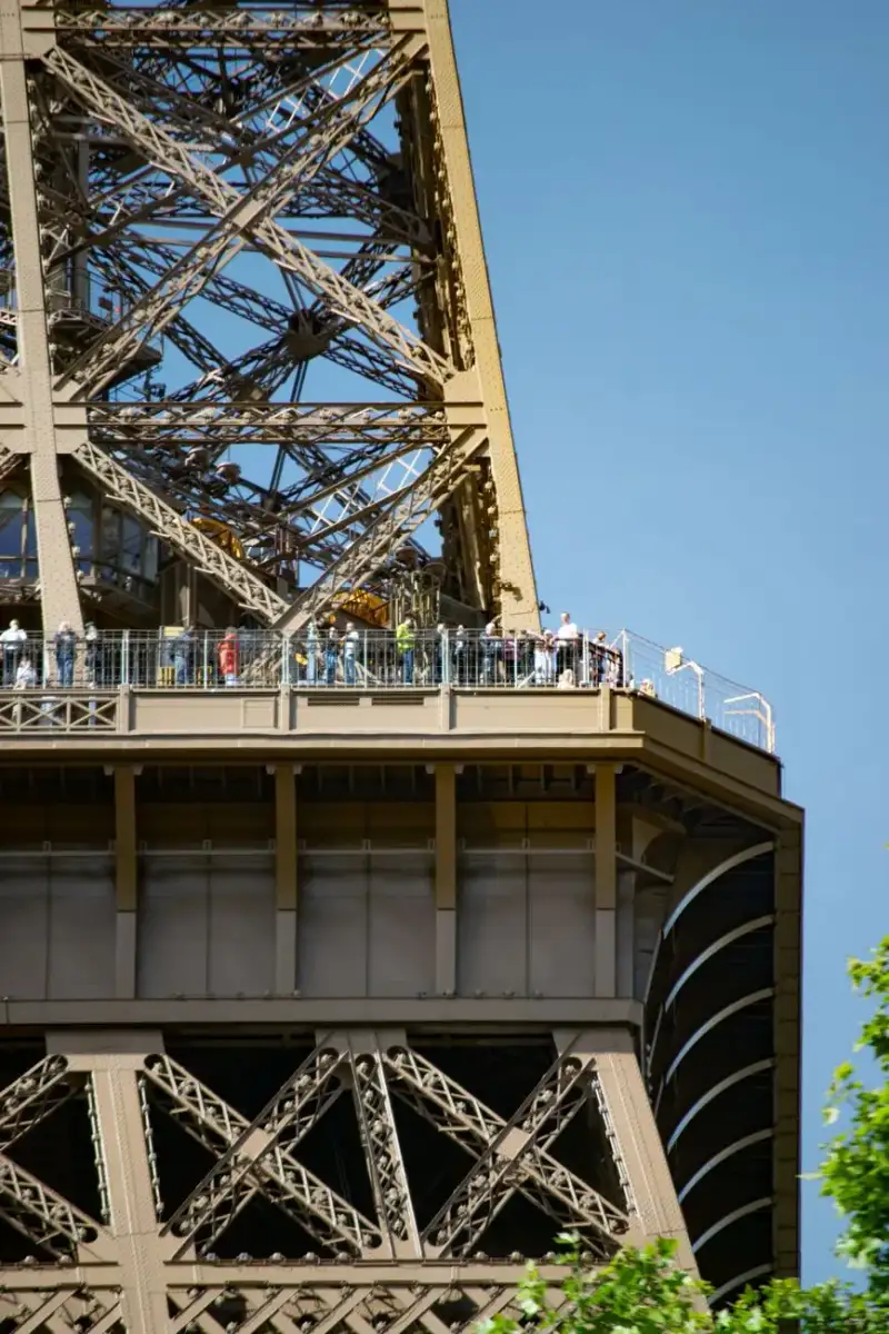 Persone che ammirano il panorama dal ponte di osservazione della Torre Eiffel, vista panoramica sulla città di Parigi con dettagli dell'intricata struttura metallica