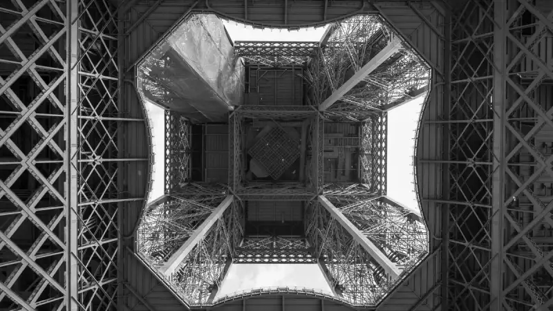 Fotografia storica in bianco e nero della costruzione della Torre Eiffel, operai su travi di ferro, Parigi 1880, rivoluzione industriale, ingegneria