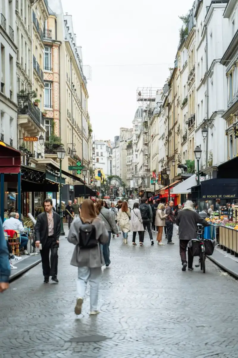 Scène animée d'un marché alimentaire parisien du 18e siècle, marchands en costumes d'époque, étals débordant de produits frais, fromages, pains, viandes, atmosphère vivante et historique