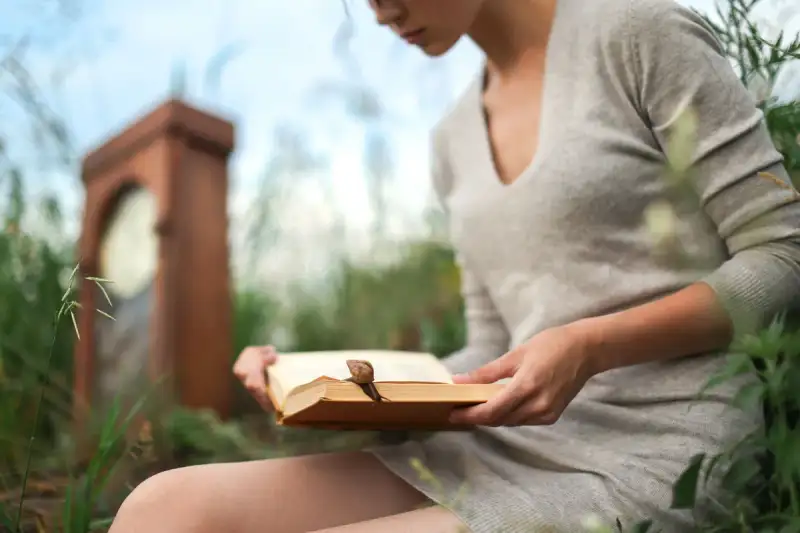 Jeune femme lisant un livre dans un environnement futuriste et sombre