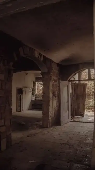 Intérieur rustique d'une maison de gardien de phare historique en Patagonie, avec des cartes maritimes et un journal de bord.