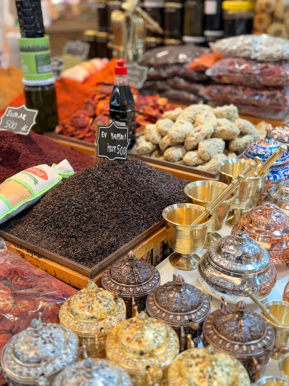 A wooden table scattered with bowls of za'atar, sumac, and baharat