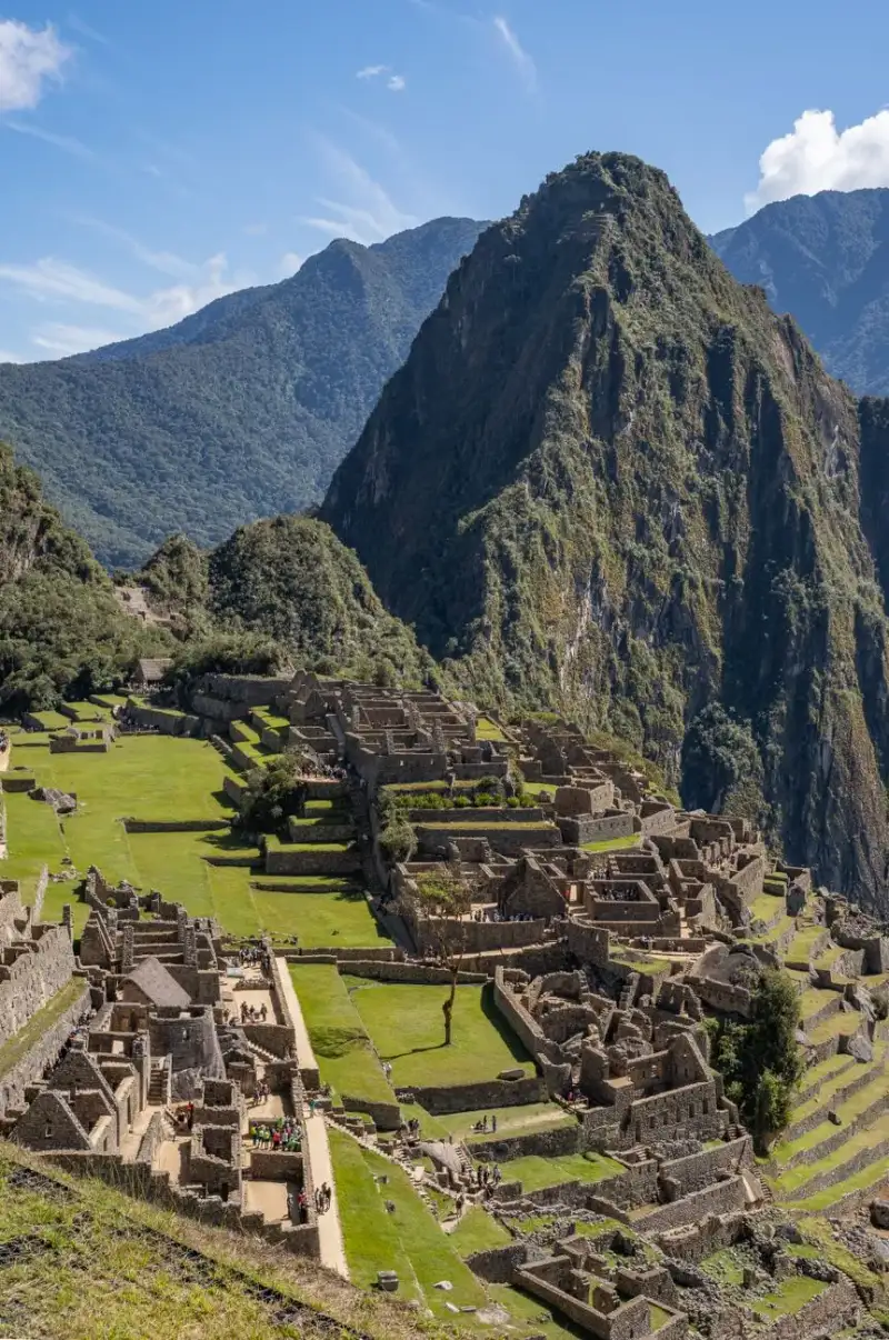 Illustration vibrante de la vie inca antique, personnes diverses en vêtements traditionnels travaillant sur des terrasses agricoles, lamas paissant, vue panoramique de Machu Picchu, représentation historique détaillée