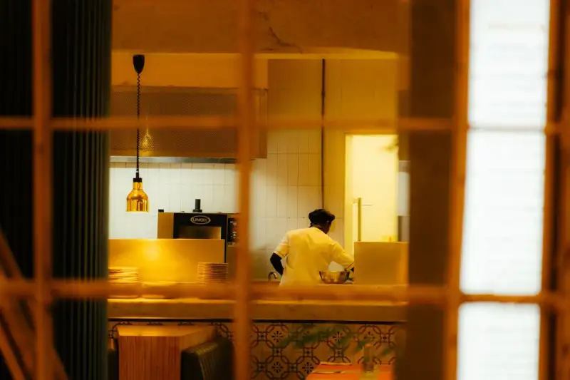 A chef expertly spreading the batter on a hot griddle