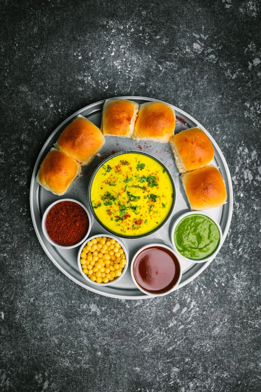 A golden fried Vada Pav on a street vendor stall