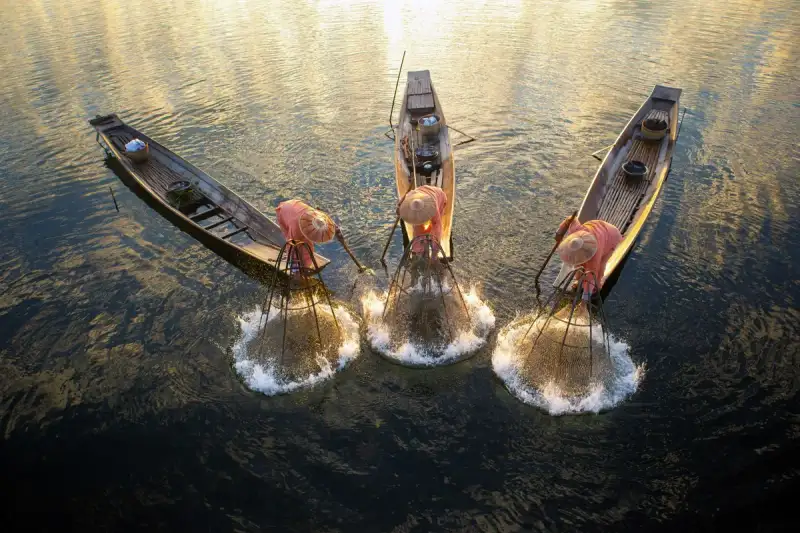 Leg-rowing fishermen at dawn on Inle Lake, Myanmar