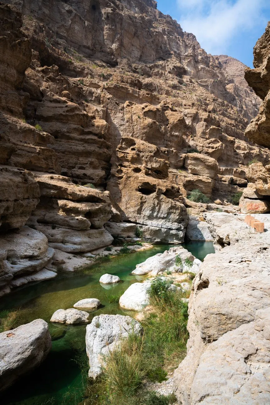 A group of hikers exploring the emerald pools of Wadi Shab