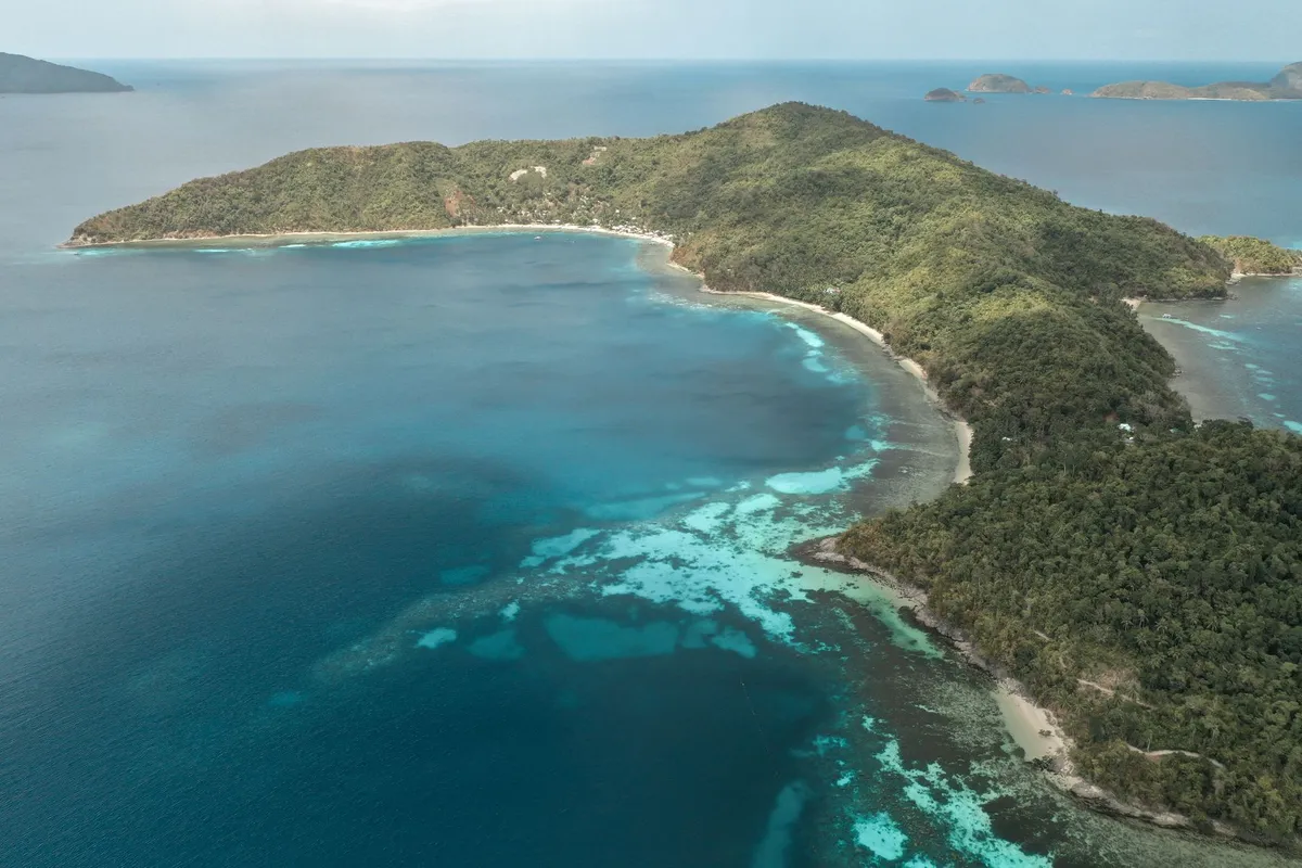 Aerial view of a secluded lagoon in Palawan surrounded by towering limestone cliffs