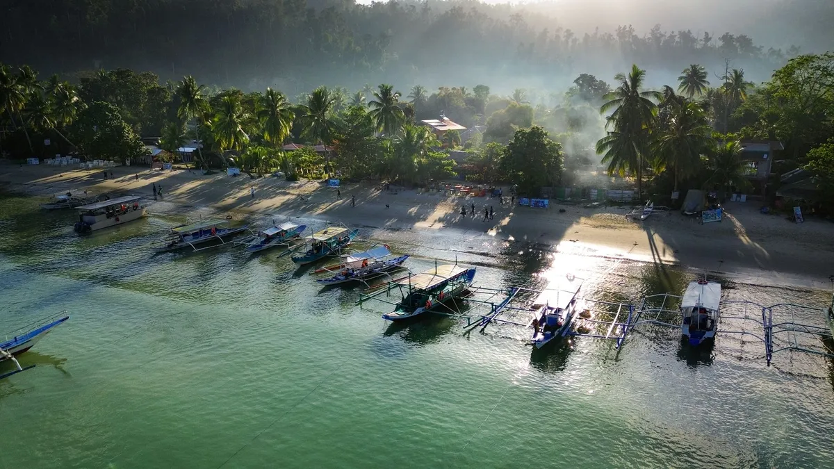 A local fisherman navigating a wooden boat through a narrow lagoon passage