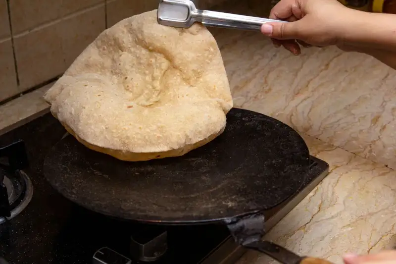 A close-up of Pav Bhaji being cooked on a Tawa