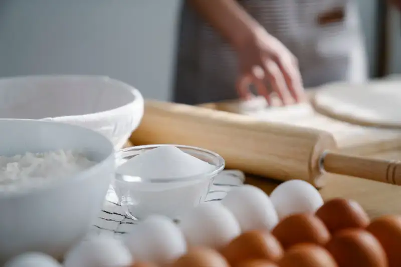 A close-up of a hand rolling out puff pastry for Pastéis de Nata