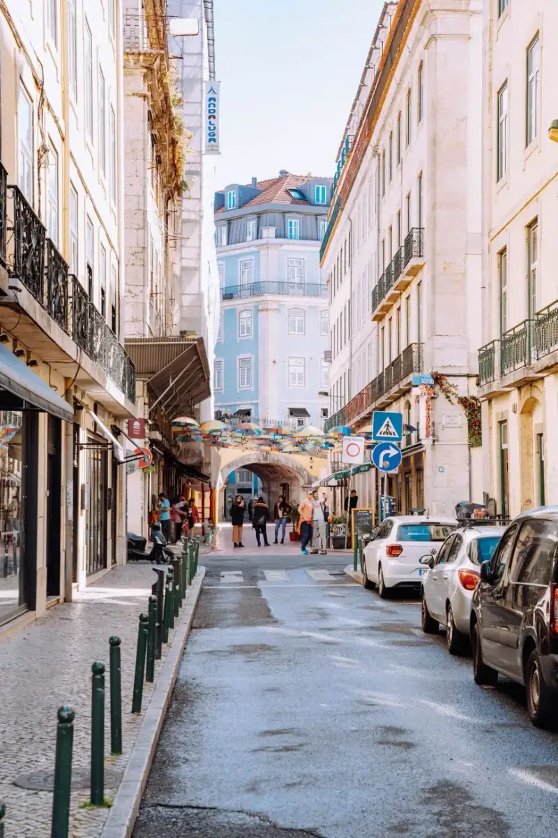 A bustling street scene in Lisbon, with a bakery sign for Pastéis de Belém