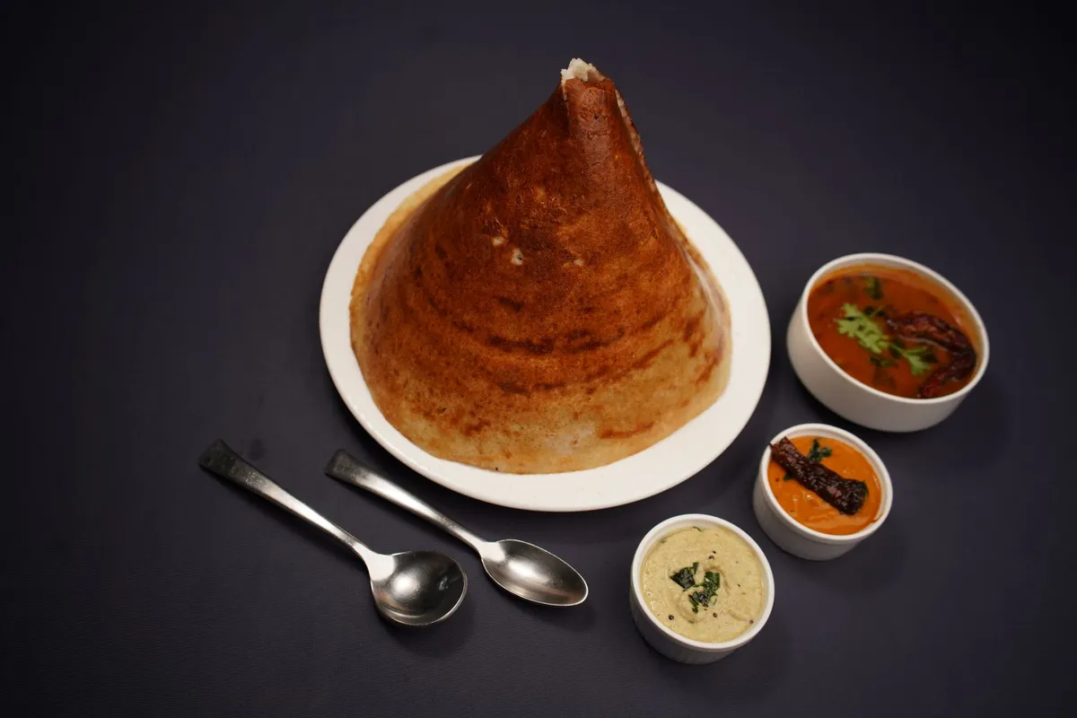 A vibrant spread of South Indian coastal dishes including appam, stew, and coconut-based curries