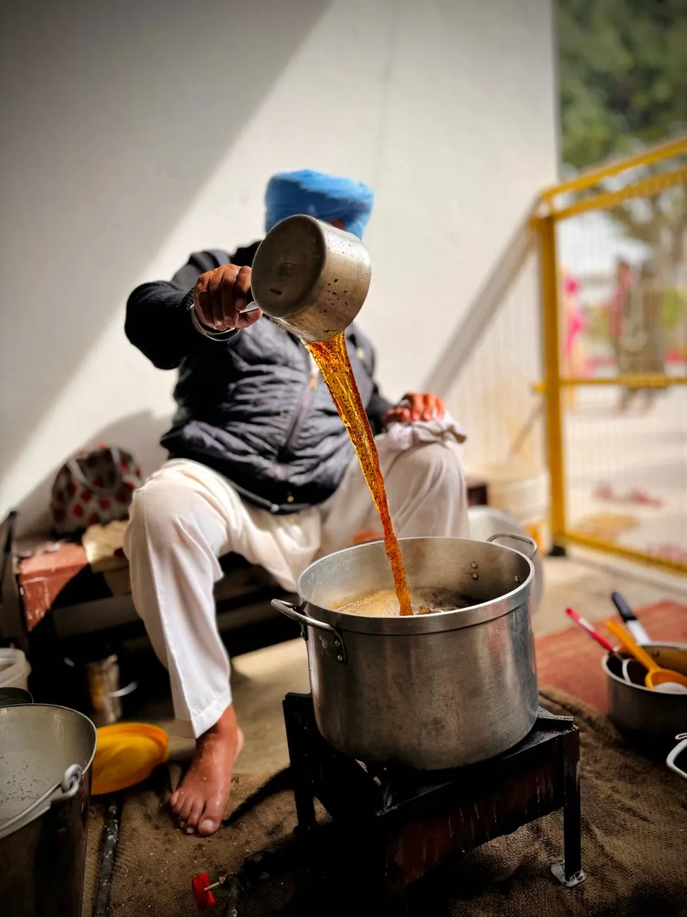 A chef preparing a South Indian vegan dish in a traditional clay pot