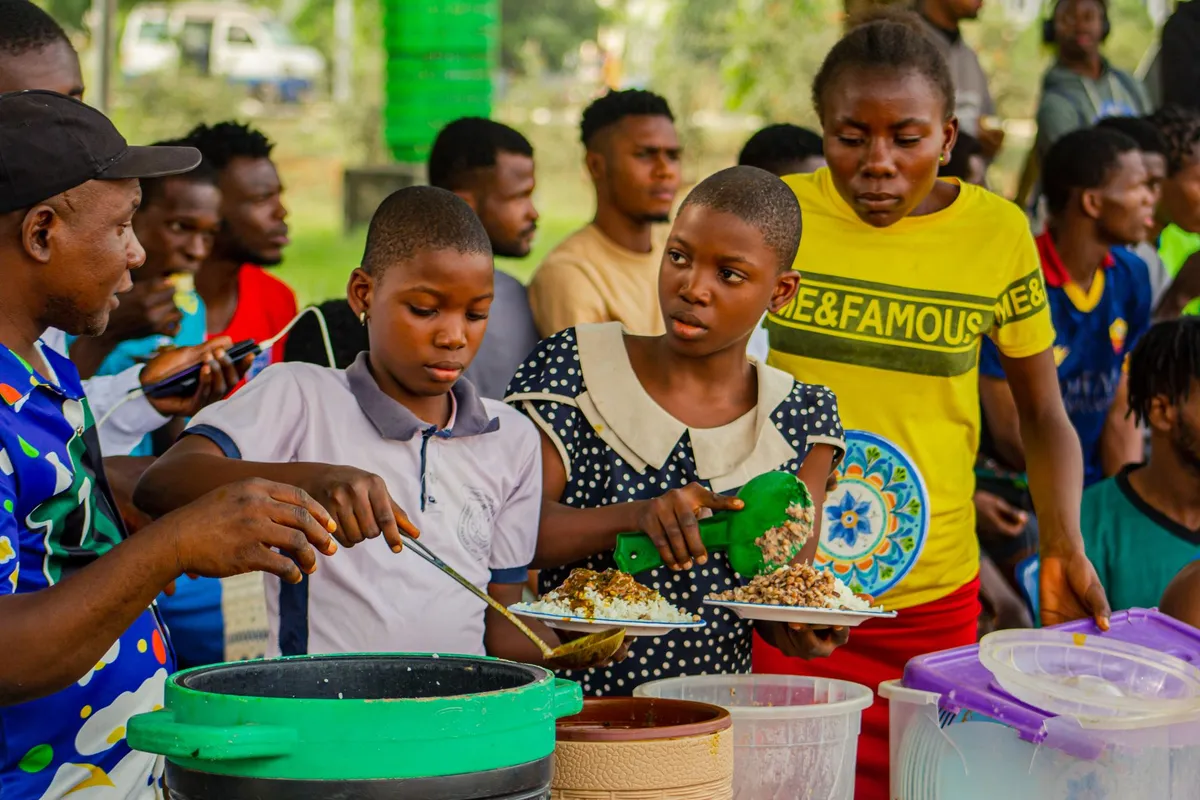 Senegalese woman serving thieboudienne in a communal setting
