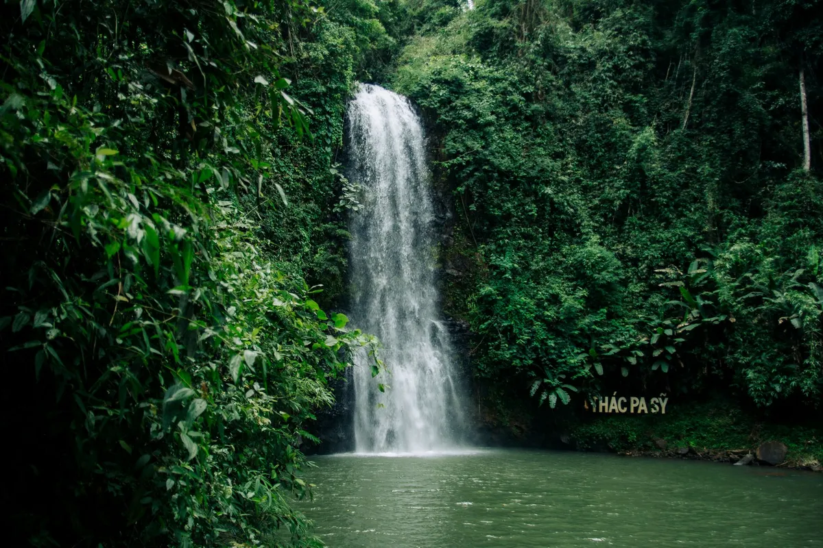 Tropical waterfall cascading into a crystal-clear pool